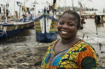 Portrait of Mrs Emelia Abaka-Edu in front of her boat in Axim village, Ghana. Photo by Anna Fawcus, WorldFish.