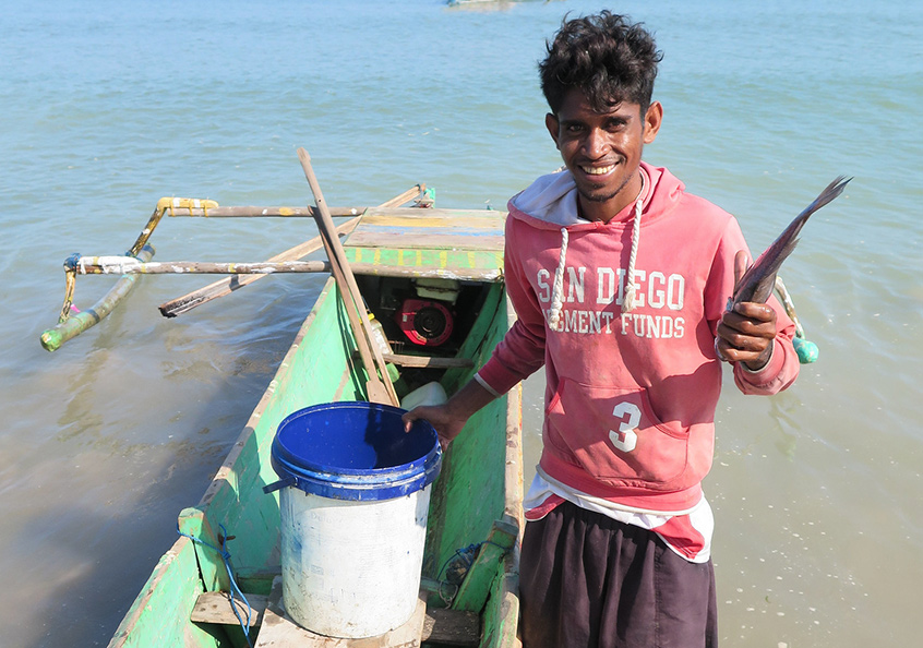 An artisanal fisher showing his catch, Beacou, Timor-Leste.