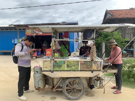 An enumerator interviewing a mobile vendor selling prepared food in Takeo province, Cambodia. Photo by Shreya Chitnavis , WorldFish.