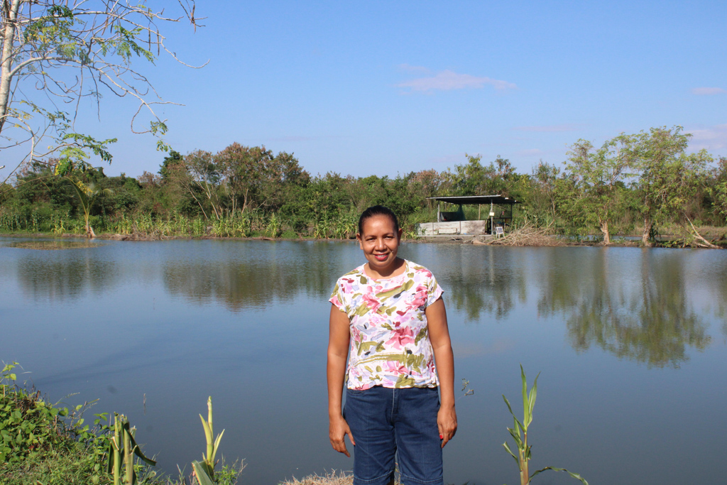 Edviges Fátima Isaac in front of one of her ponds in Colocao, measuring 100 x 50 metres. Photo by Carlos Alves Almeida.