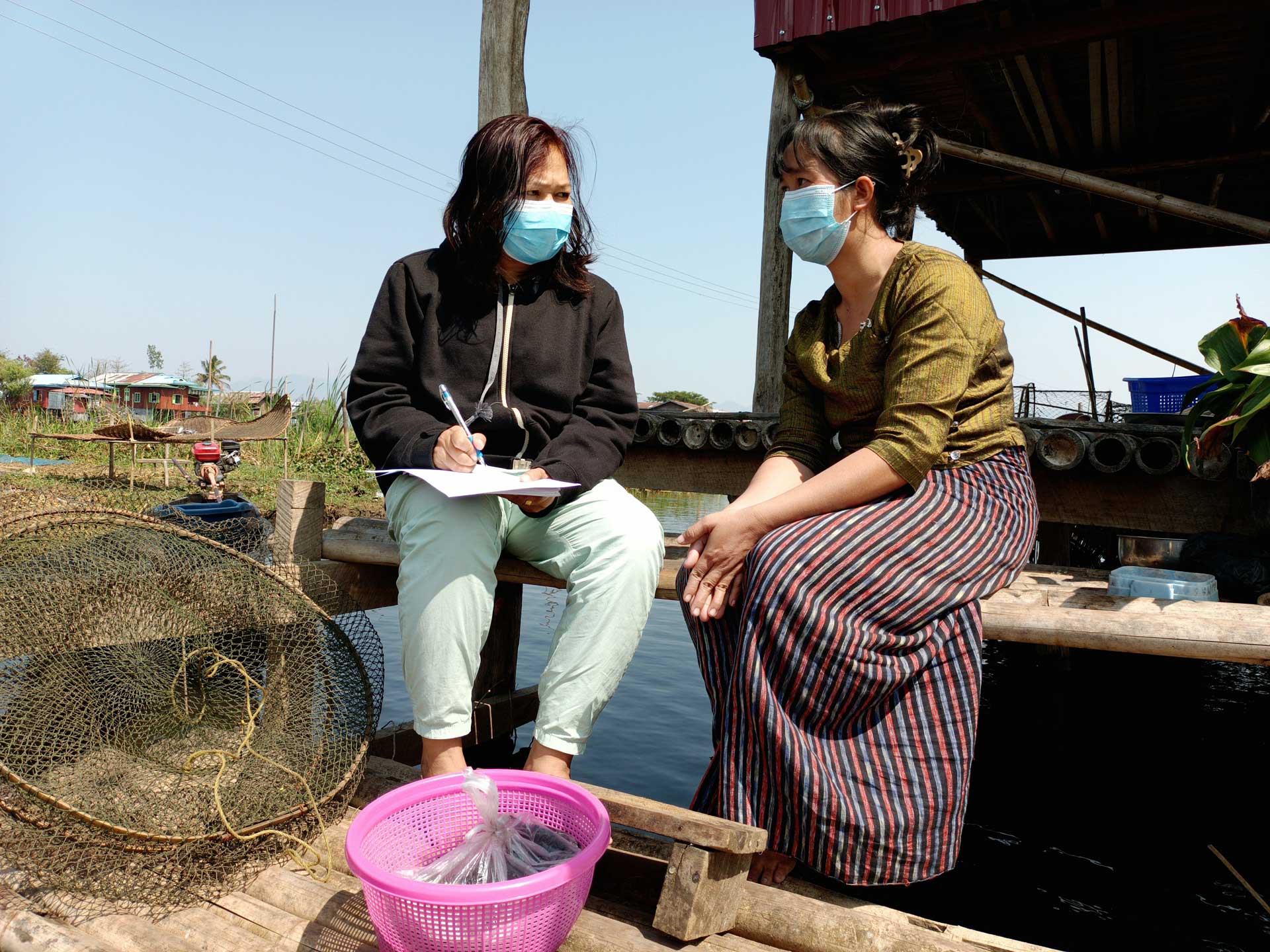 WorldFish Information Education Communication and Training Assistant Aye Nyein Zaw interviews Daw Lae Lae Soe (right) on her experience during COVID-19. Photo by Kyaw Moe Oo.