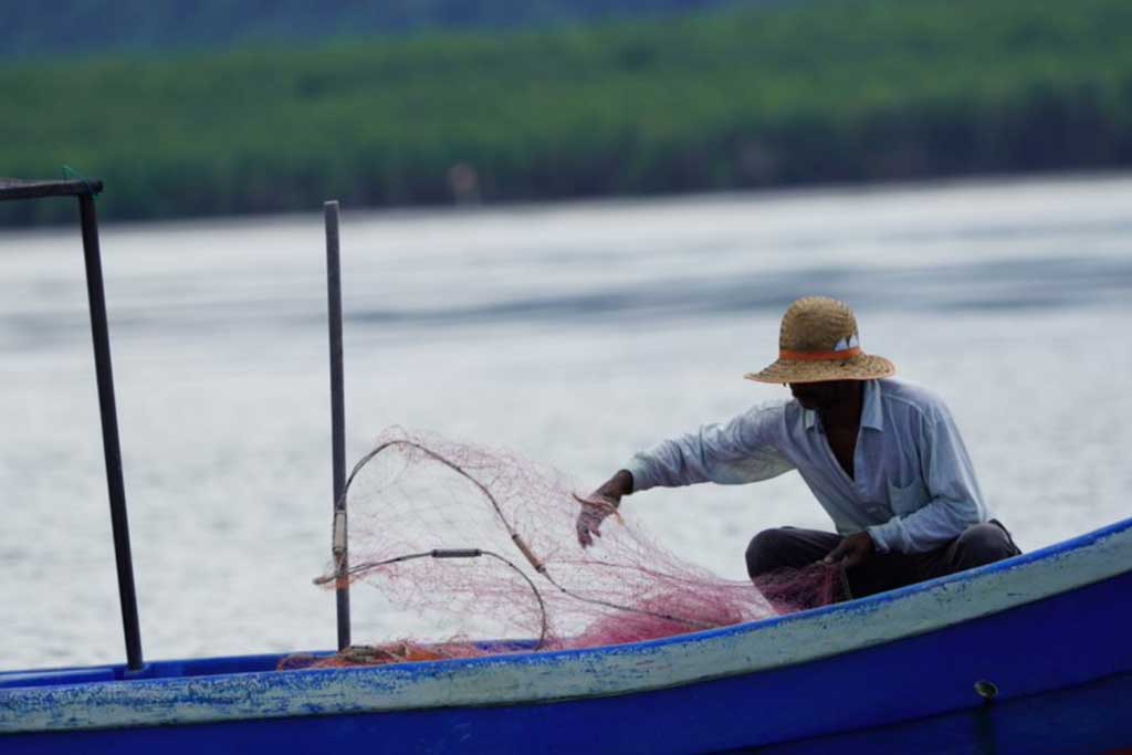 Small-scale fisher adjusts fishing net. Photo by Muhammad Hafizullah Mirhassan, WorldFish