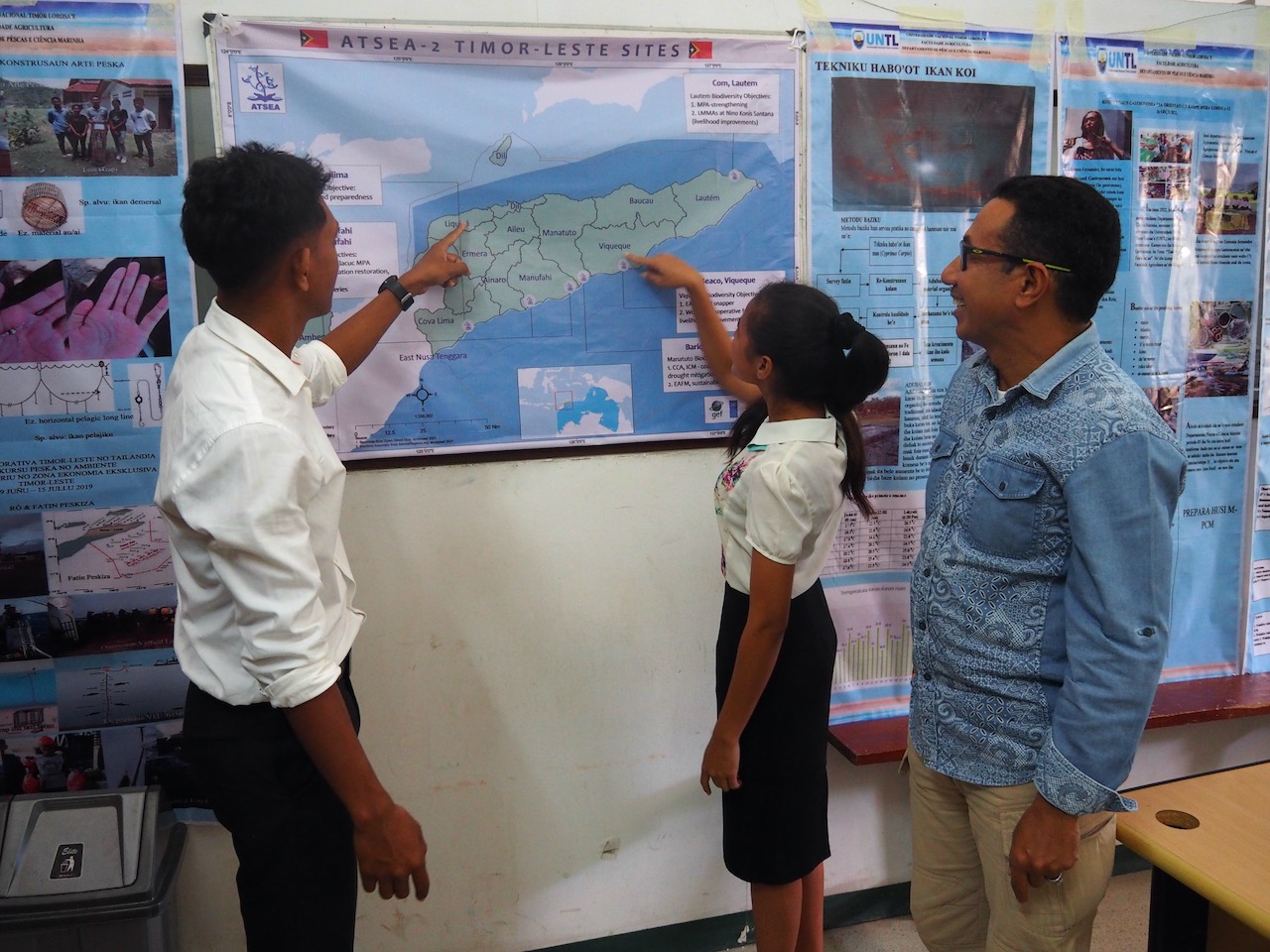 Fifth-year marine science students Gloria da Silva and Otelio dos Santos show Professor Mario Cabral the locations of their field research. Photo by Kate Bevitt.