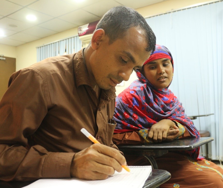 Abdul Razzak puts his business expansion plans down on paper and intends to support his wife, Kolpona Bibi open a bank account. Photo by Maherin Ahmed.