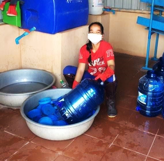 A water kiosk operator taking extra safety precautions to ensure her business could continue at a WorldFish project water kiosks.