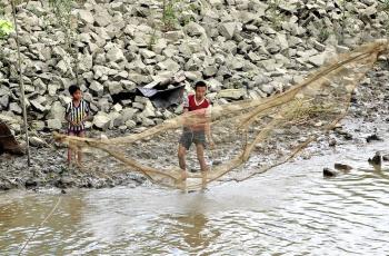 Fisherman and son fishing in the Twante Canal, Myanmar. Photo by Michael Akester.
