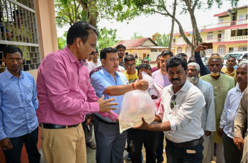 Munindra Nath Ngatey handing over oxygen-packed bags of mola seeds to farmers. Photo: Sourabh Kumar Dubey