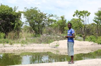A man in Mungwi District stands next to his tilapia fish pond in Northern Province, Zambia. Photo by Kendra Byrd.