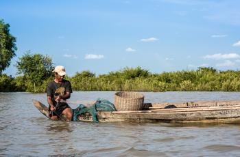 A fisherman checking his net, Cambodia. Photo by Finn Thilsted.