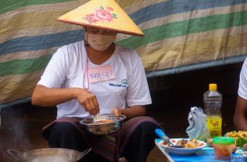 A woman cooking food and adding spices to the dish during the Nutrition month celebration in Taunggyi, Southern Shan. Photo by WorldFish.