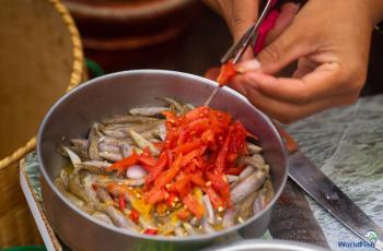 A participant adding red chilies to SIS to serve to panel in cooking demonstration during Nutrition month celebration in Taunggyi, Southern Shan. Photo by WorldFish.