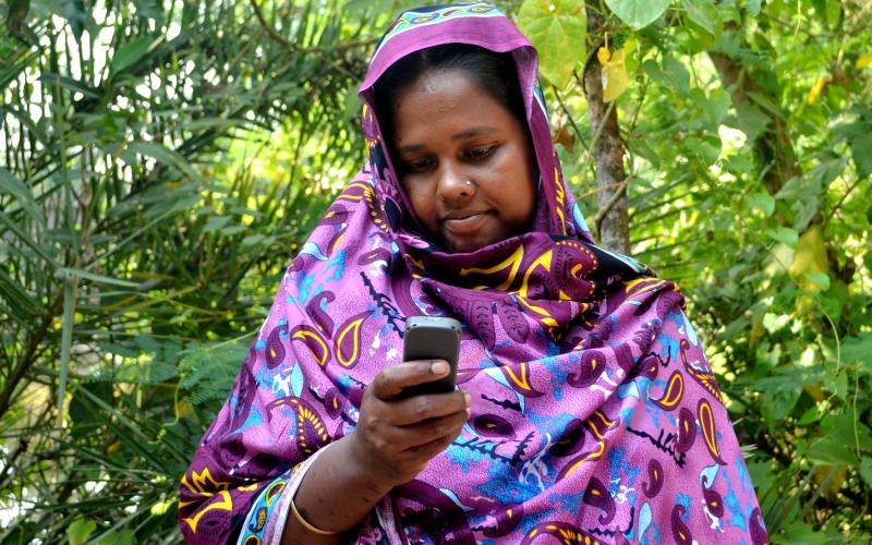A Bangladeshi fisherwoman receives payment on her mobile phone. Photo by Sayma Islam.