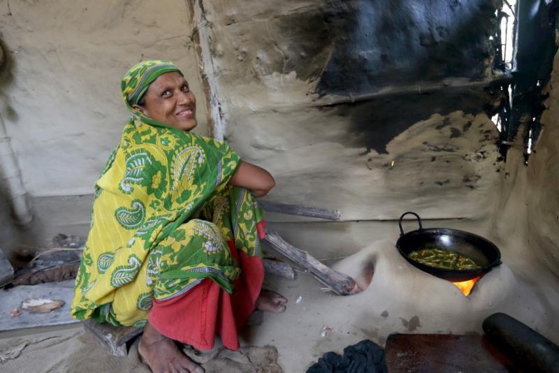 A woman cooking mola curry in her kitchen in Jessore, Bangladesh.