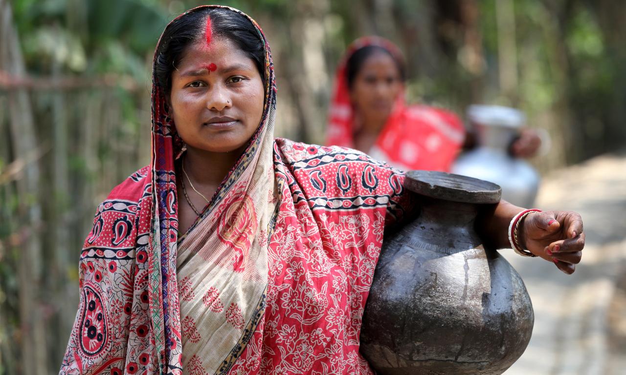 Komola Roy carrying drinking water in Fultola Village, Khulna, Bangladesh