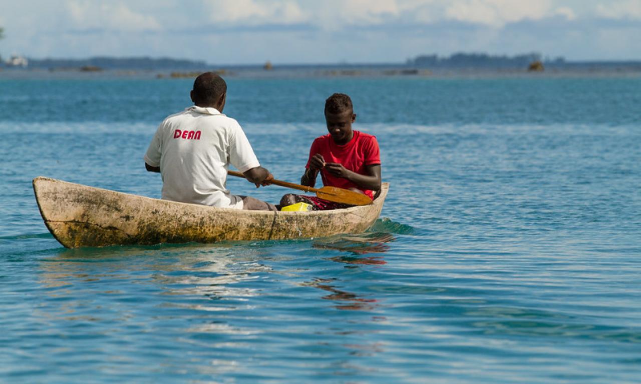 Men paddle out to reef to catch fish in the Solomon Islands. Photo by Filip Milovac.