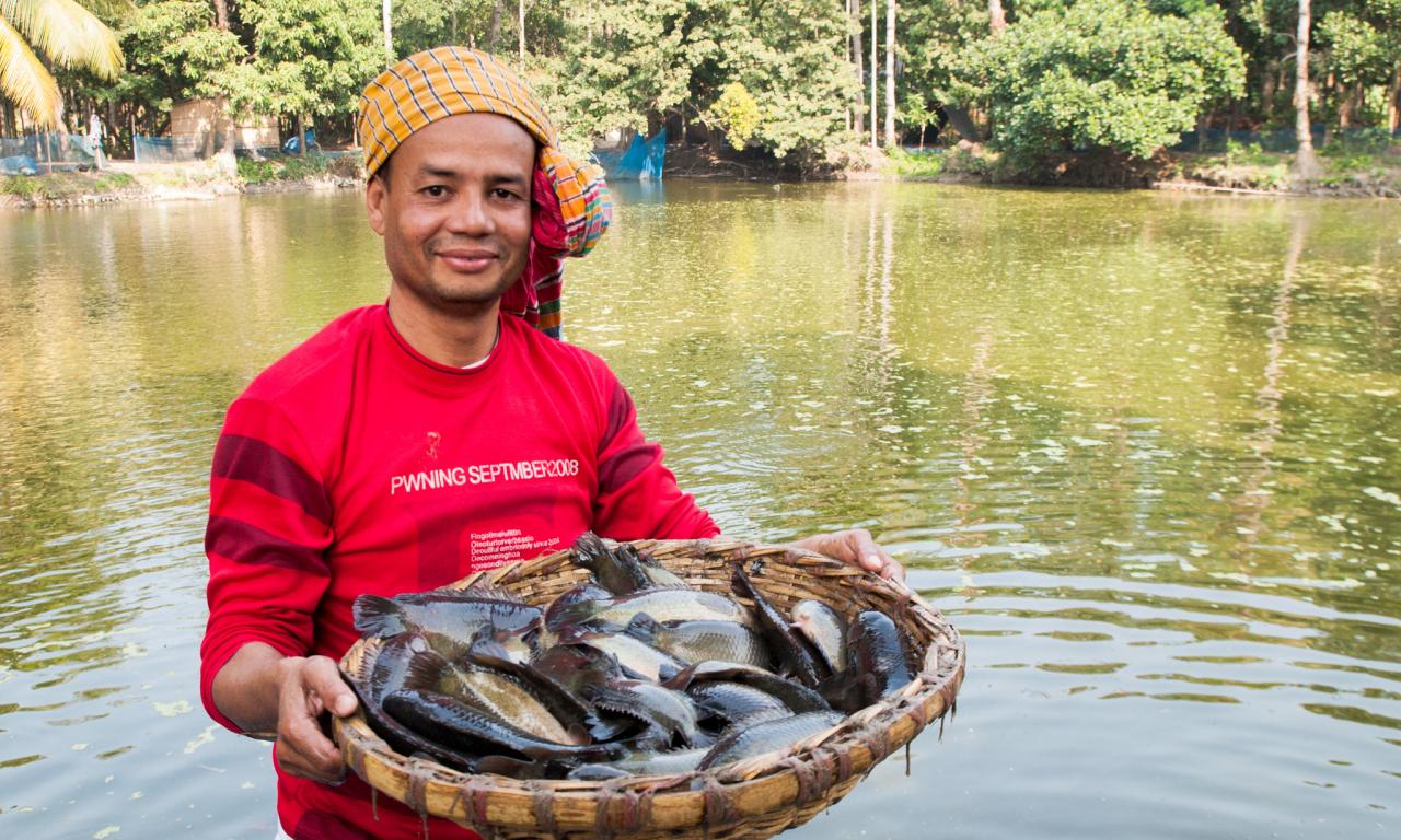 A Bangladeshi farmer poses with the climbing perch fish harvested from his aquaculture pond. The Gates Foundation is in the process of investing in the country’s smallholder aquaculture sector. Photo by Balaram Mahalder.