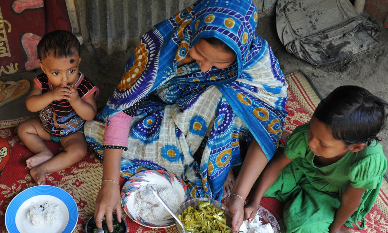 A Bangladeshi mother feeding her children nutrient-rich small fish and leafy vegetables. Photo by Finn Thilsted.