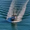 Close up photo of a boat creating a wake in the surrounding water 